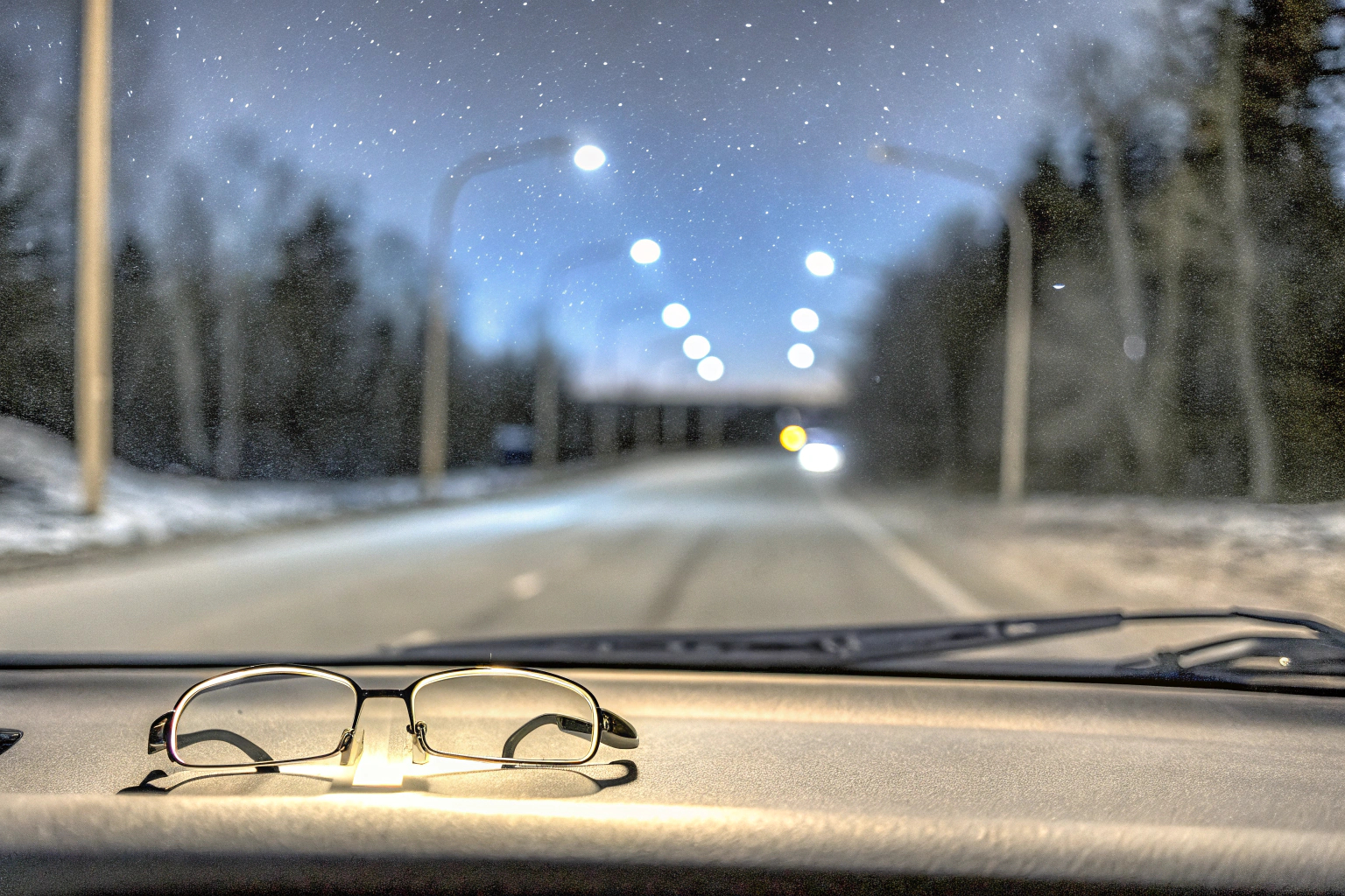 Person trägt Nachtfahrbrille beim Autofahren